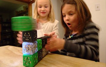 girls playing with simple robotic cubes